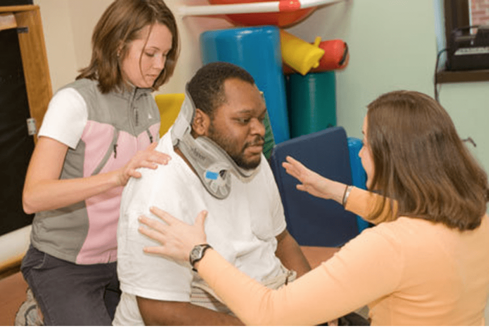 nurses helping man with spinal cord injury