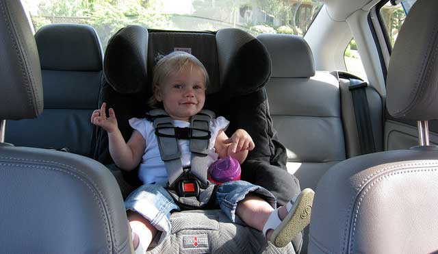 smiling toddler in a car seat
