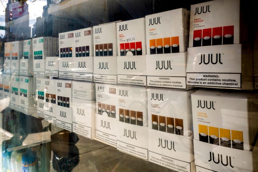 Juul brand vaping supplies in the window of a smoke shop