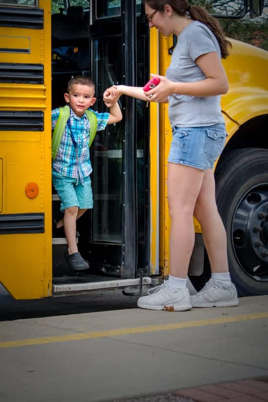 Mom Helps Her Child Step off the School Bus.