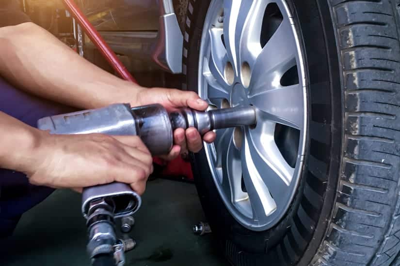 Mechanic Using Airgun to Remove Lugnuts From Car