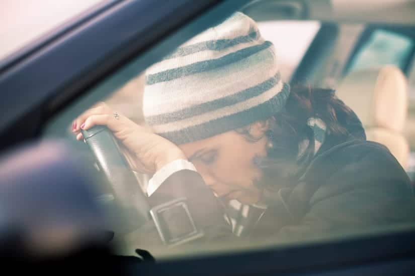Woman Driving While Stressed, Head Resting On Steering Wheel.