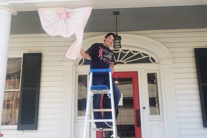 Kathleen hanging pink banner for Breast Cancer Awareness