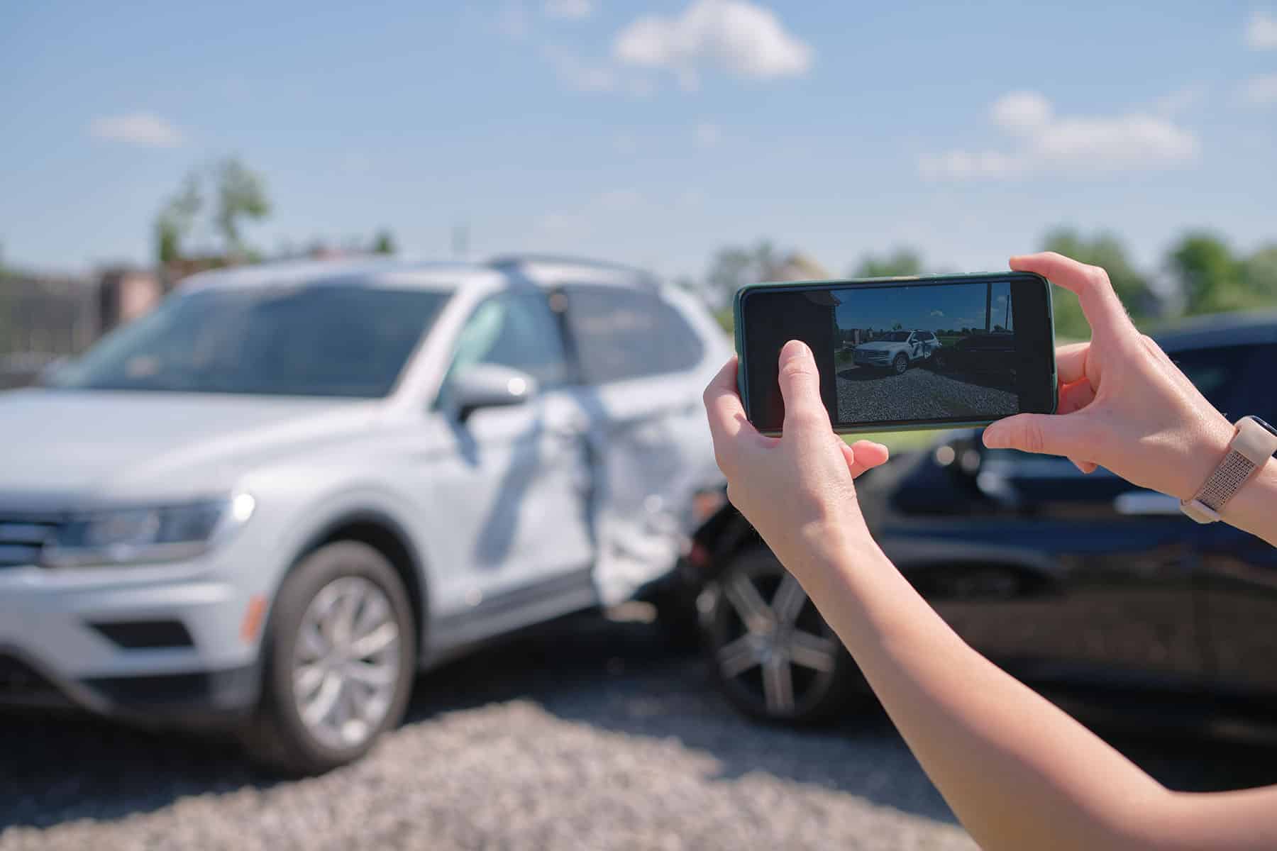 Close up of driver hands taking photo after auto accident